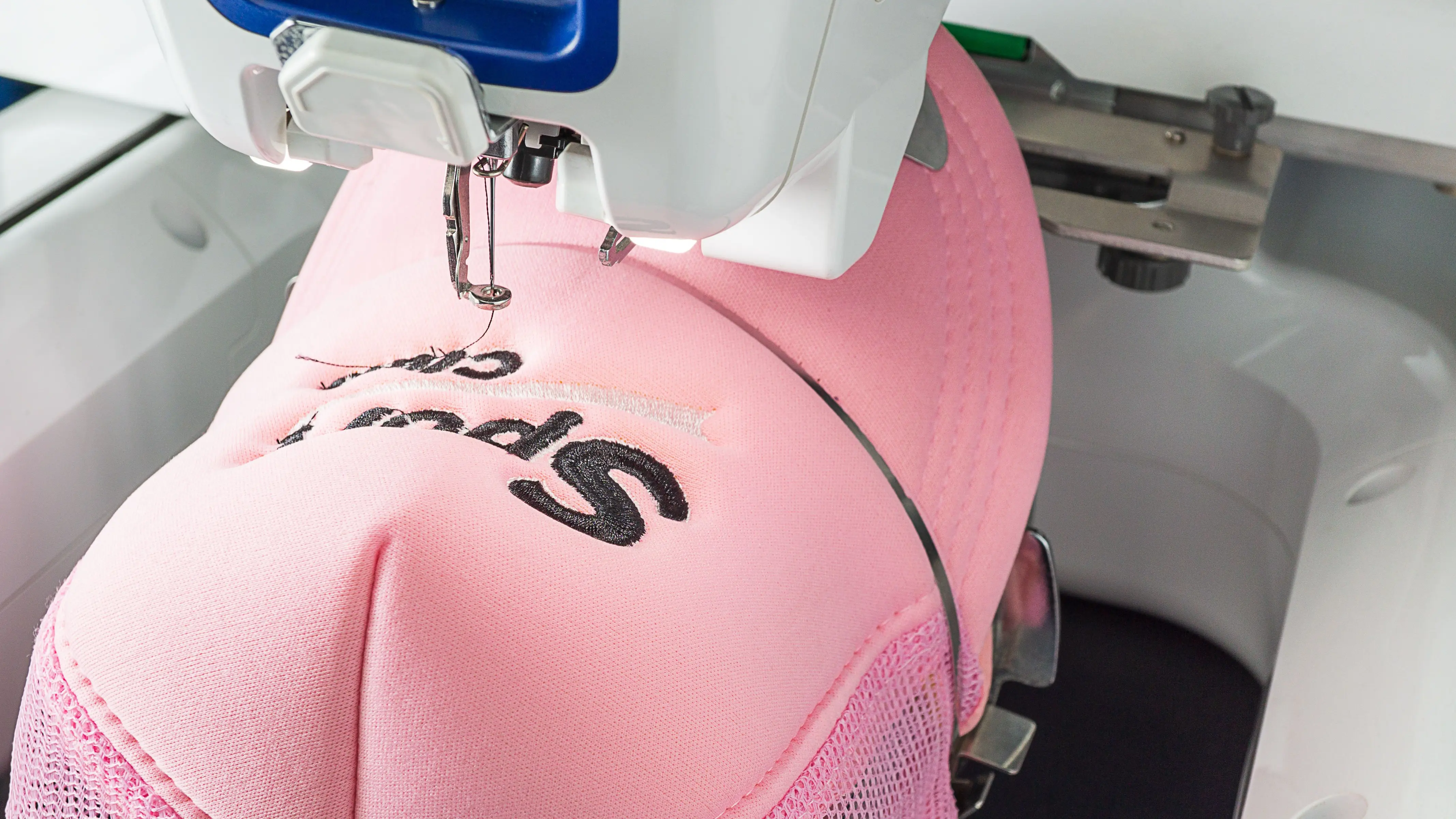 Cap embroidery machine stitching personalized text - Styledev.in custom embroidery services
